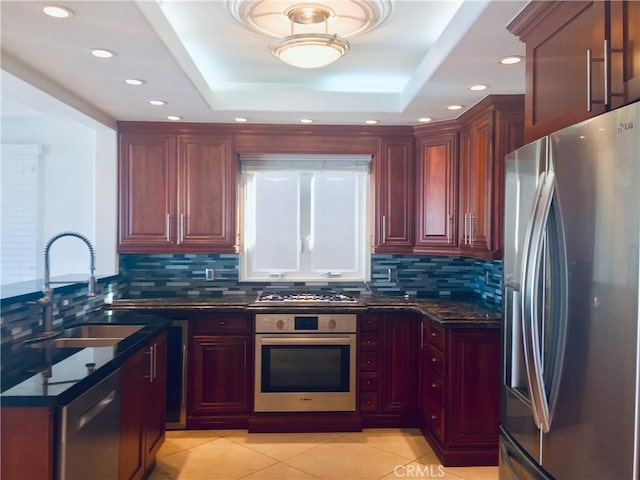 kitchen with stainless steel appliances, a raised ceiling, sink, and light tile patterned floors