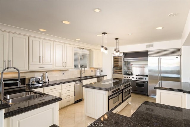 kitchen with pendant lighting, sink, a center island, and high quality appliances