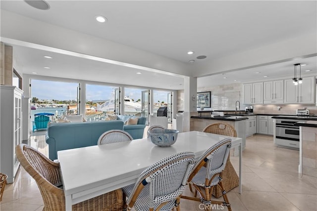 dining area featuring sink and light tile patterned floors