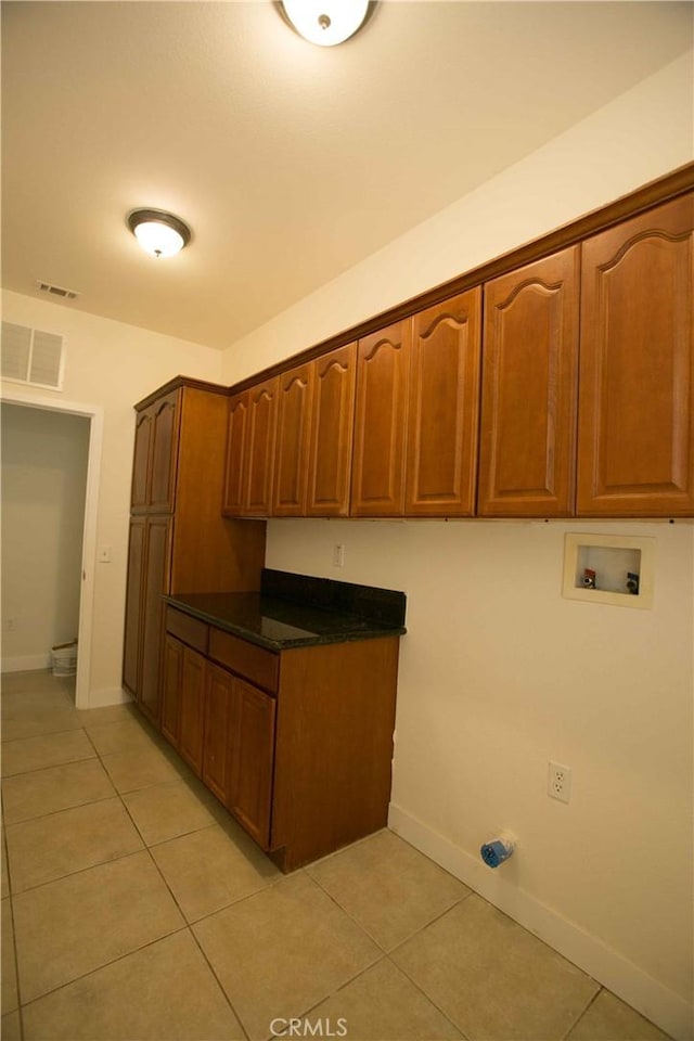 kitchen with dark stone counters and light tile patterned flooring