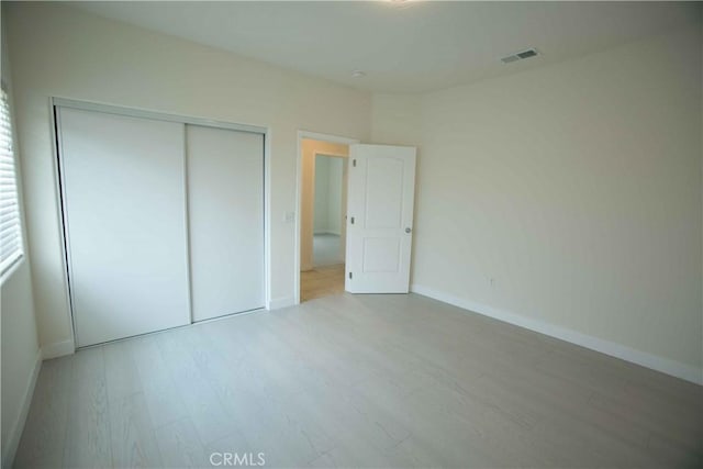 unfurnished bedroom featuring a closet and light hardwood / wood-style flooring