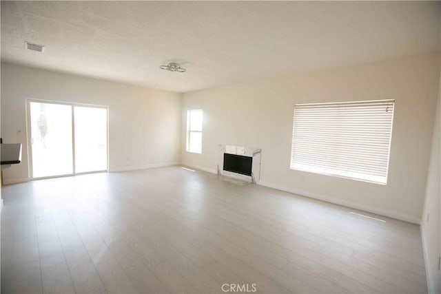 unfurnished living room with a fireplace and light hardwood / wood-style flooring