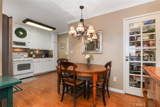 dining area featuring a chandelier, ornamental molding, and light hardwood / wood-style floors