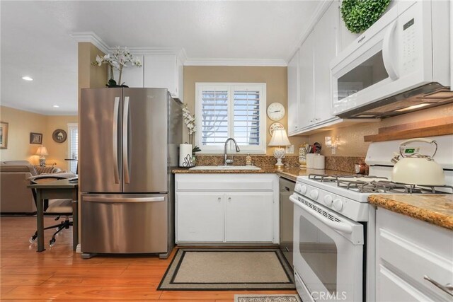 kitchen featuring white cabinetry, sink, white appliances, and ornamental molding