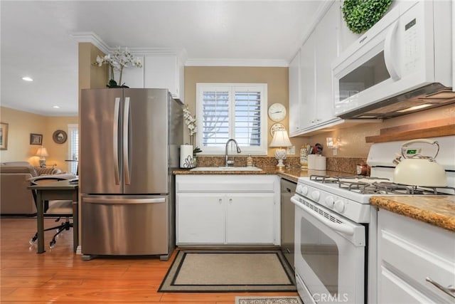 kitchen featuring ornamental molding, sink, white cabinets, and white appliances