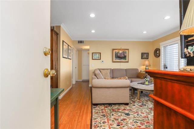 living room featuring ornamental molding and light hardwood / wood-style floors