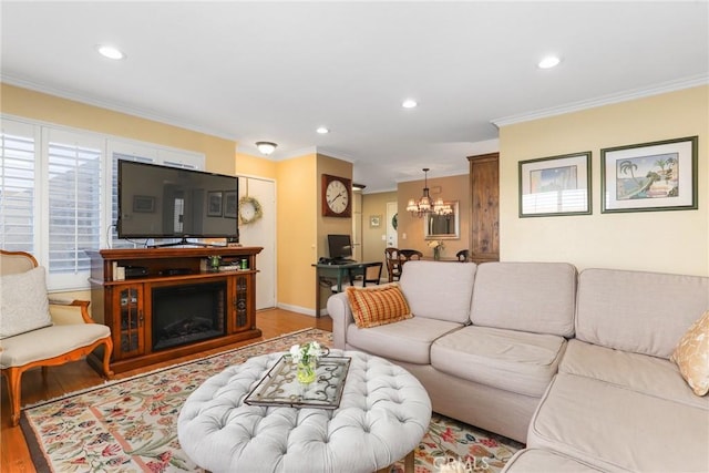 living room with crown molding, wood-type flooring, and an inviting chandelier