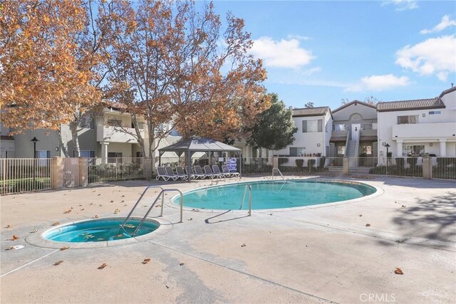 view of pool featuring a hot tub and a patio area