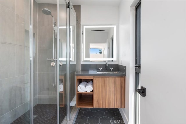 bathroom featuring tile patterned flooring, a shower with door, and vanity