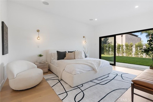 bedroom with access to exterior and light hardwood / wood-style flooring