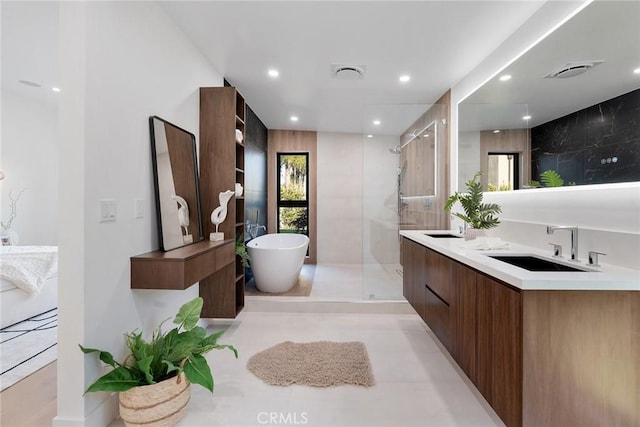 bathroom featuring independent shower and bath, tile patterned floors, and vanity