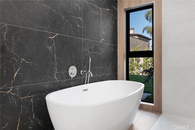 bathroom with tile walls and a tub