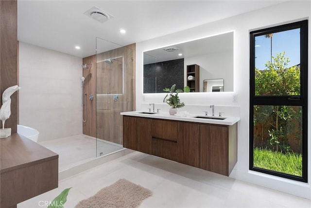 bathroom with walk in shower, vanity, and a wealth of natural light