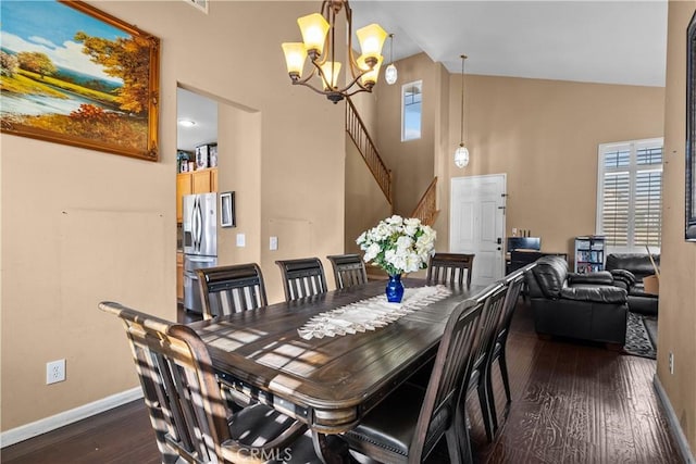 dining space with dark wood-type flooring, high vaulted ceiling, and a notable chandelier