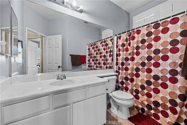 bathroom featuring tile patterned floors, vanity, toilet, and walk in shower