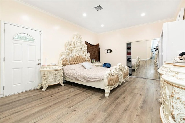 bedroom with light wood-type flooring and ornamental molding