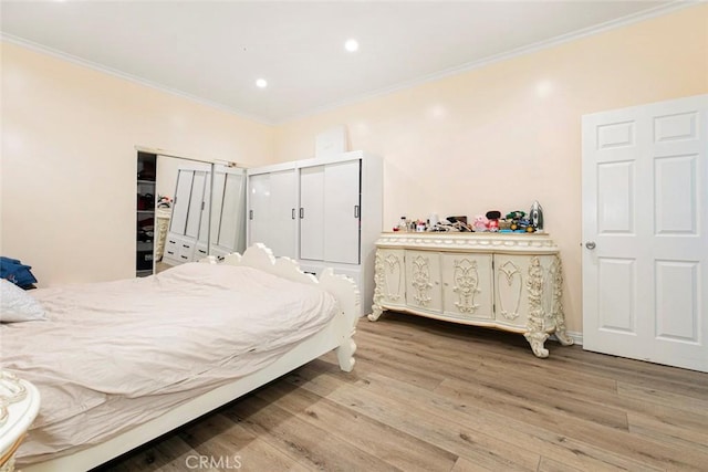 bedroom with a closet, crown molding, and hardwood / wood-style floors