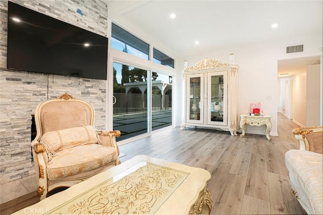 living area with vaulted ceiling and light hardwood / wood-style floors