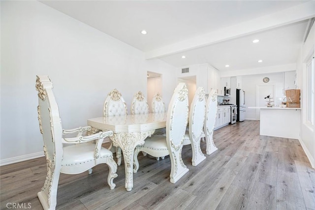 dining room featuring light hardwood / wood-style floors and beam ceiling