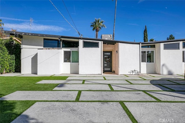 view of front facade with a front lawn and a patio