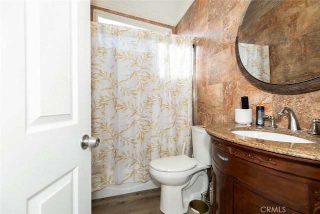 bathroom with toilet, vanity, wood-type flooring, and crown molding