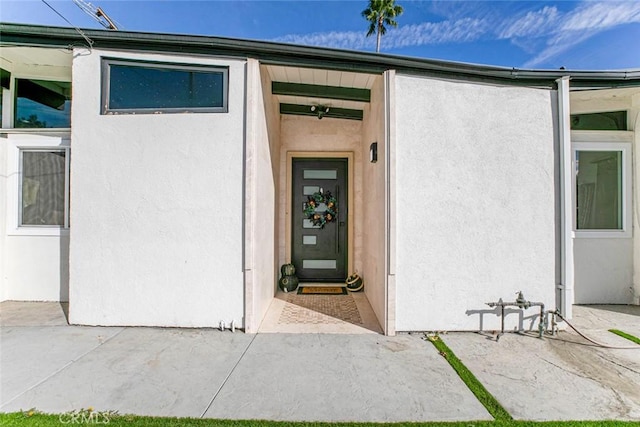 view of exterior entry with a patio area