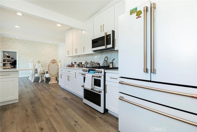 kitchen with white cabinetry, range, and high end white refrigerator