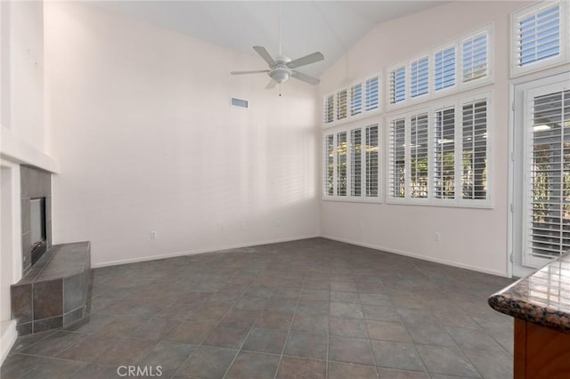 unfurnished sunroom with lofted ceiling, ceiling fan, and a fireplace