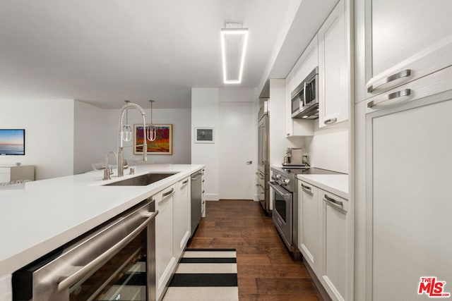 kitchen featuring beverage cooler, white cabinetry, dark hardwood / wood-style flooring, stainless steel appliances, and sink