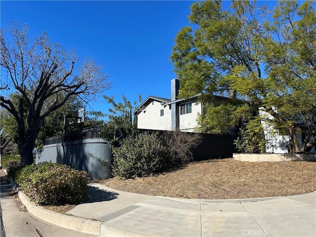 view of side of property with fence and stucco siding