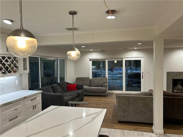 living area with wood finished floors, a high end fireplace, and recessed lighting