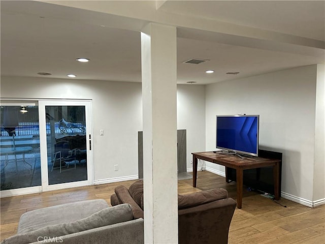 living room with recessed lighting, visible vents, baseboards, and wood finished floors