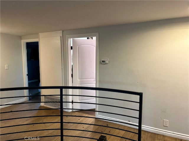 hall featuring wood finished floors and baseboards