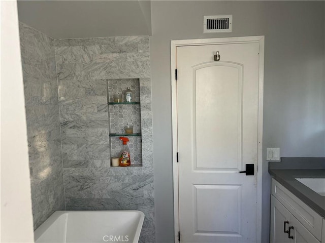 bathroom featuring a bathtub, visible vents, and vanity