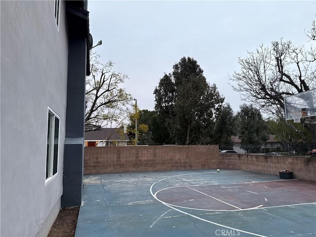 view of basketball court featuring fence and basketball court