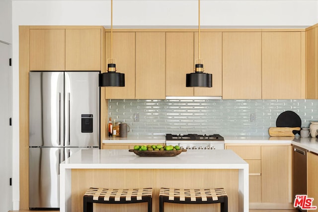 kitchen featuring range, light brown cabinets, tasteful backsplash, stainless steel fridge, and a breakfast bar area