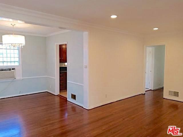 unfurnished room with dark wood-type flooring, cooling unit, and crown molding