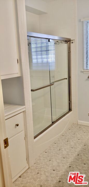 bathroom featuring shower / bath combination with glass door