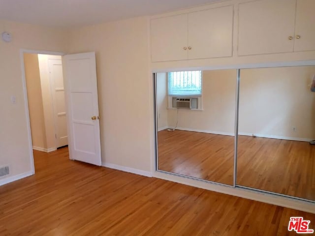 interior space with hardwood / wood-style flooring, cooling unit, and a closet