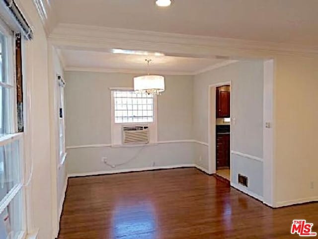 unfurnished room with dark wood-type flooring, crown molding, and a notable chandelier