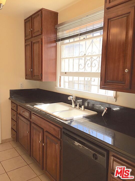 kitchen featuring light tile patterned floors, dishwasher, and sink