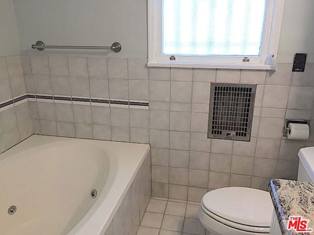 bathroom featuring tile walls, toilet, a bath, and tile patterned flooring