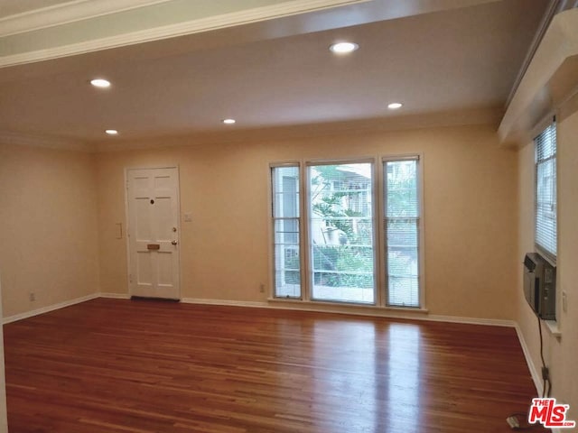 spare room featuring cooling unit, dark hardwood / wood-style floors, and crown molding