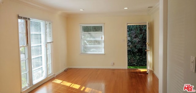 spare room with crown molding and light hardwood / wood-style floors