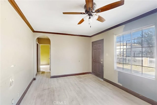 empty room with light wood-type flooring, ceiling fan, and crown molding