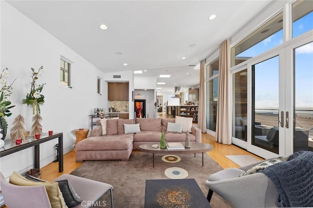 living area featuring light wood-style floors, recessed lighting, and visible vents