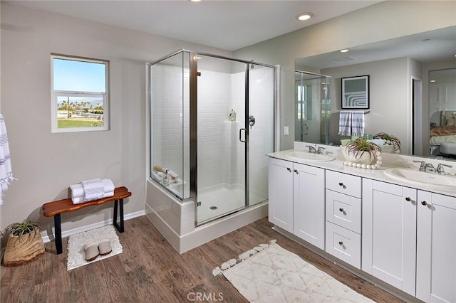 bathroom with walk in shower, vanity, and wood-type flooring