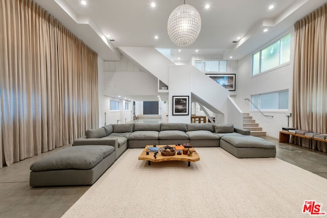 living room featuring concrete floors and a towering ceiling