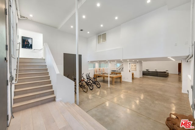 stairs featuring concrete floors and a towering ceiling