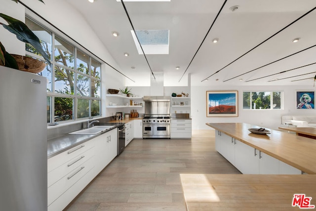 kitchen featuring sink, white cabinetry, appliances with stainless steel finishes, and plenty of natural light